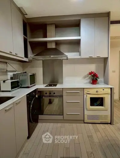 Modern kitchen with sleek cabinetry, built-in appliances, and stylish flooring, perfect for culinary enthusiasts.