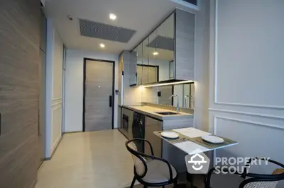 Modern kitchen with sleek cabinetry and dining area in luxury apartment