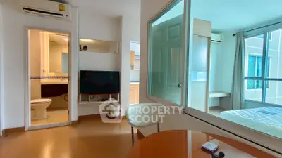 Modern apartment interior with open layout, featuring a cozy living area and a glimpse into the bedroom.