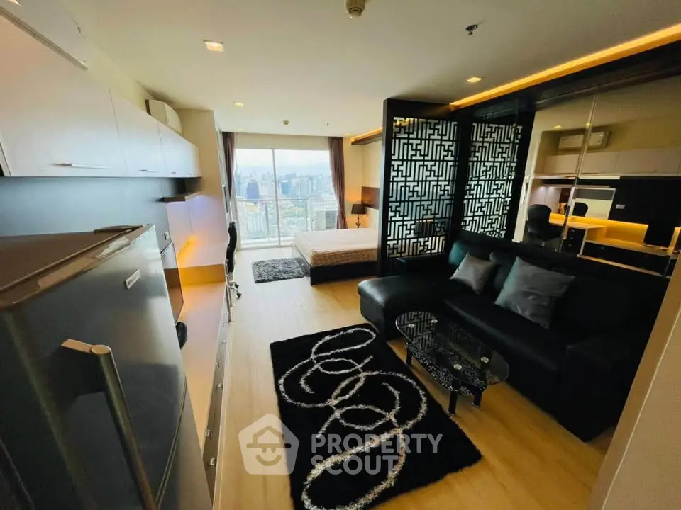 Modern studio apartment with city view, featuring sleek black furniture and stylish decor.