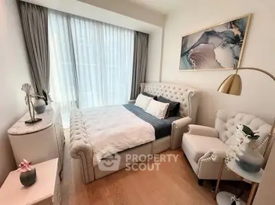 Luxurious bedroom with elegant decor and natural light, featuring plush bed and stylish armchair.