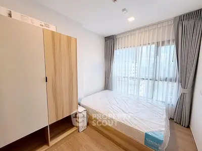 Modern bedroom with large window and stylish wooden wardrobe
