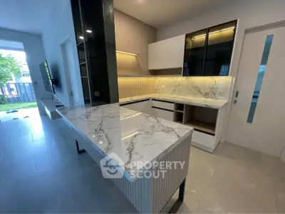 Modern kitchen with marble countertops and sleek cabinetry in a stylish open layout.