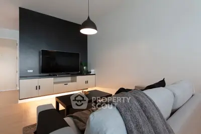 Modern living room with sleek black accent wall and cozy gray sofa.