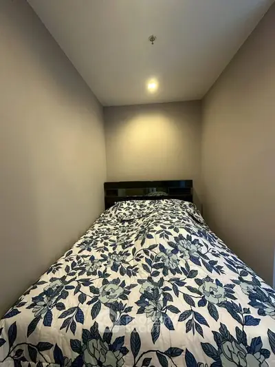 Cozy bedroom with floral bedding and soft lighting, perfect for relaxation.