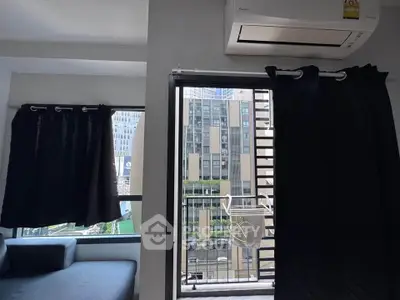 Modern apartment living room with balcony and city view, featuring sleek air conditioning unit.
