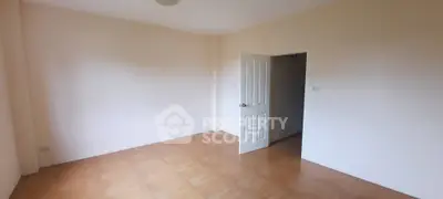 Spacious empty room with tiled flooring and open door