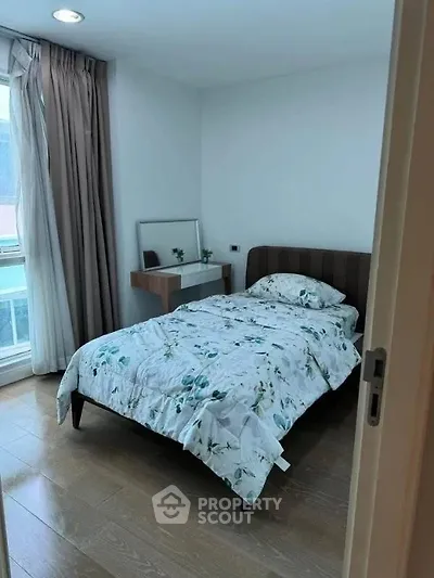 Cozy bedroom with single bed and natural light from large window