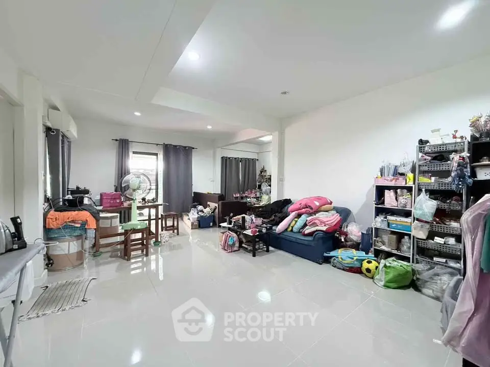 Spacious living room with modern decor and ample natural light, perfect for family gatherings.