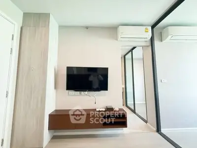 Modern living room with wall-mounted TV and air conditioning in a stylish apartment.