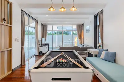 Spacious living room with pool table and modern decor, perfect for entertainment and relaxation.