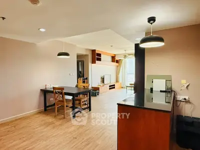 Spacious open-plan living and dining area with modern lighting and wooden flooring.