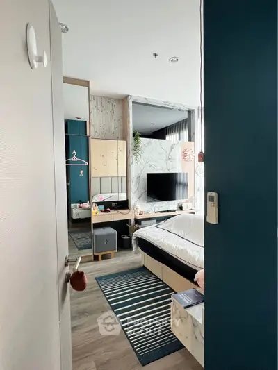 Modern bedroom with stylish decor, featuring a wall-mounted TV and cozy bed setup.
