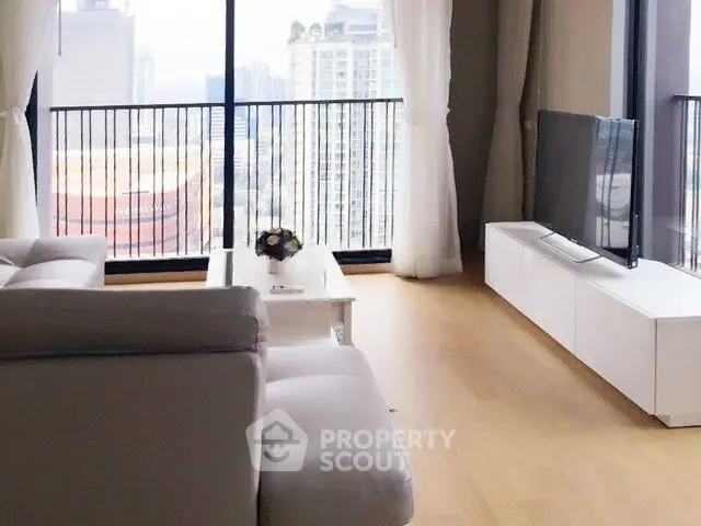 Spacious living room with city view and modern furnishings in high-rise apartment.