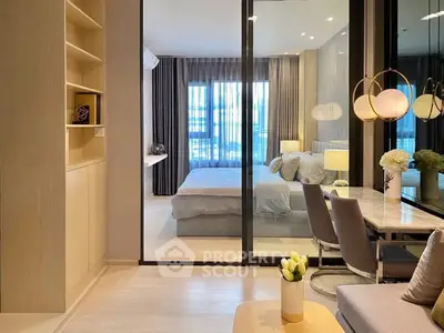 Modern open-plan living room with glass partition to stylish bedroom.