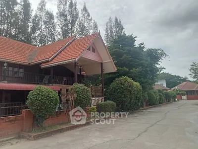 Charming traditional-style homes line a peaceful street, boasting terracotta roofs, lush greenery, and inviting brick fences, perfect for serene living.