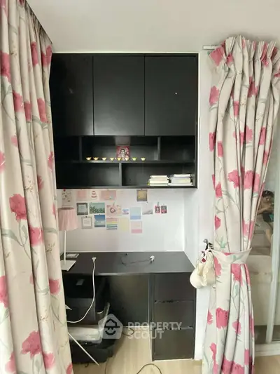 Charming study nook with floral curtains and sleek black cabinetry, perfect for a cozy home office setup.