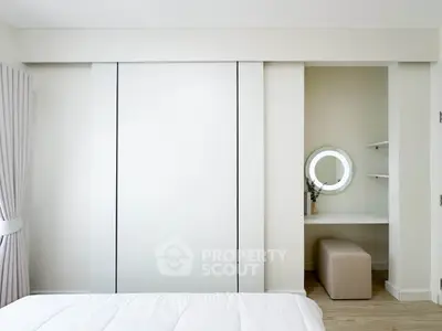 Modern bedroom with sleek sliding closet doors and stylish vanity area.