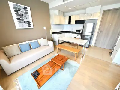 Modern open-layout living room with stylish kitchen and cozy seating area, perfect for urban living.