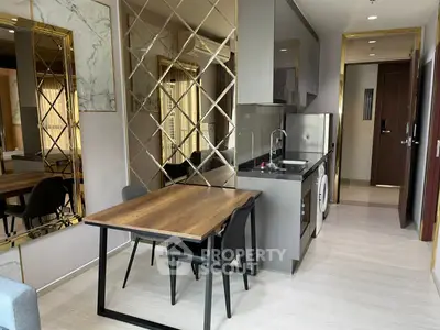 Modern kitchen with sleek design, featuring a compact dining area and stylish mirrored accents.