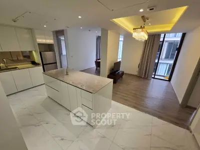 Spacious open-plan kitchen and living room with modern design and elegant lighting.