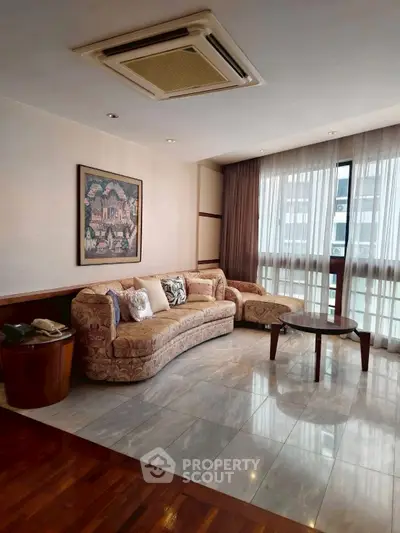 Spacious living room with elegant sofa and large window for natural light.