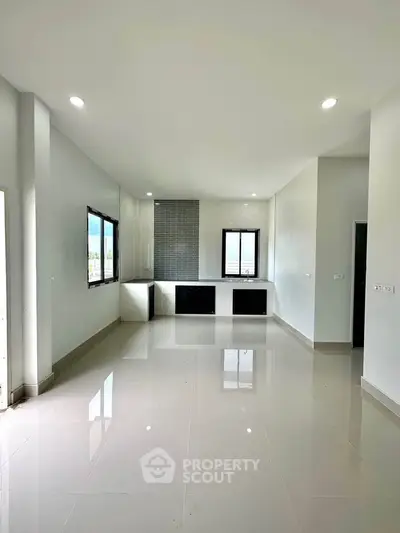 Spacious modern living room with large windows and sleek tile flooring