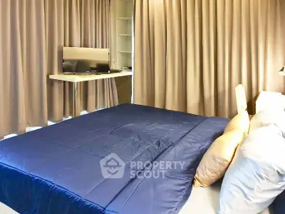 Modern bedroom with cozy bedding and wall-mounted TV, ideal for relaxation.