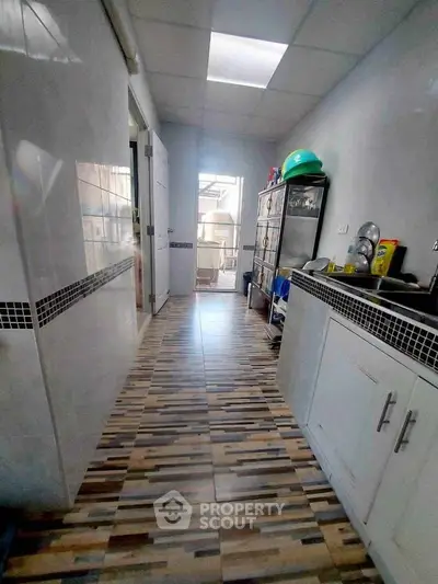 Spacious kitchen with modern cabinets and tiled flooring, ideal for culinary enthusiasts.