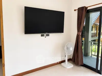 Modern living room with wall-mounted TV and sliding glass door to balcony