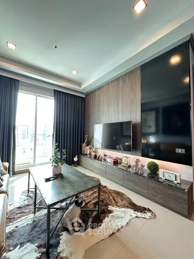 Modern living room with stylish decor and large TV, featuring floor-to-ceiling windows.