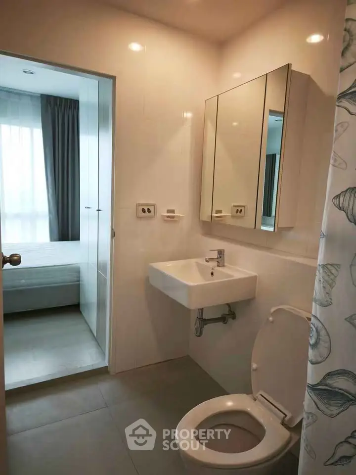 Modern bathroom with sleek fixtures and a glimpse of a cozy bedroom, perfect for urban living.