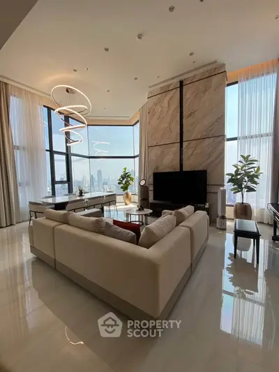 Luxurious living room with panoramic city views, modern decor, and elegant lighting fixtures.