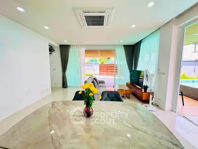 Spacious modern living room with large windows and elegant decor, perfect for relaxation and entertainment.