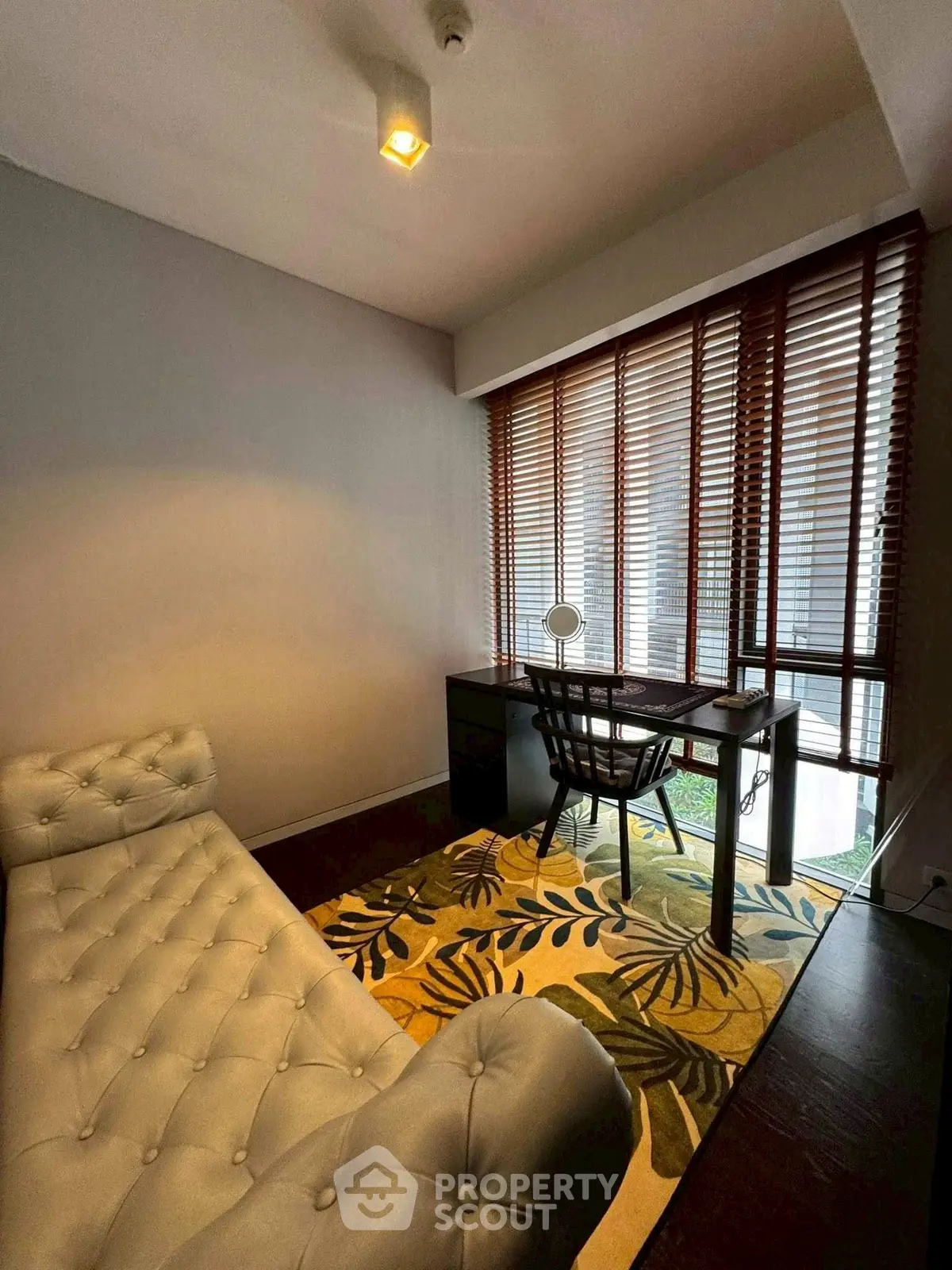 Chic study room with stylish chaise lounge and elegant desk by large window.