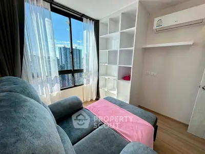 Modern living room with large window and city view, featuring cozy sofa and air conditioning.