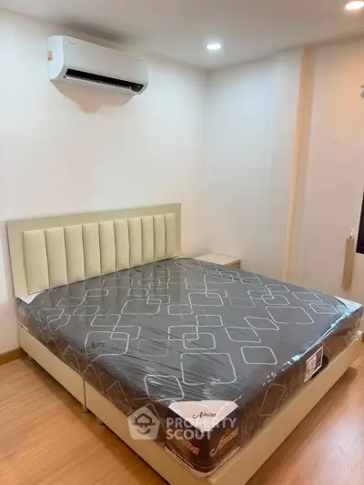 Modern bedroom with stylish bed and air conditioning in a cozy apartment.