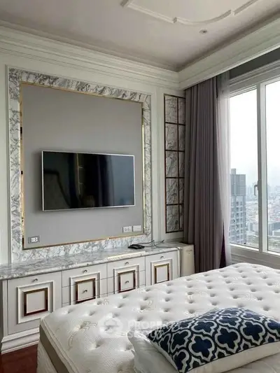Luxurious bedroom with elegant decor and city view, featuring a mounted TV and plush bedding.
