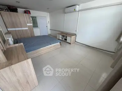 Spacious bedroom with modern wooden furniture and air conditioning