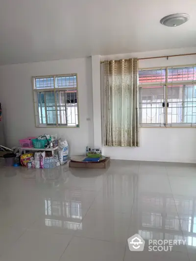 Spacious empty room with tiled floor and large windows, perfect for customization.