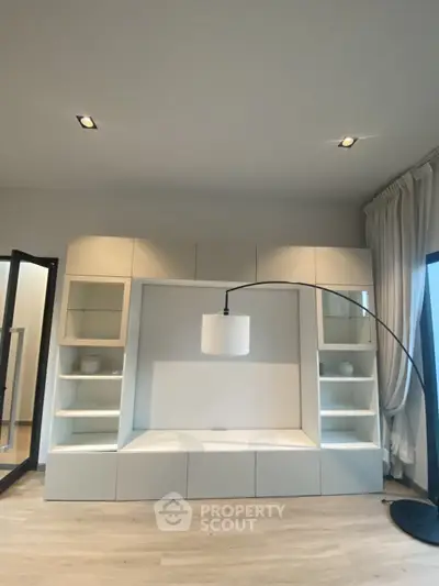 Modern living room with stylish built-in shelving and elegant floor lamp
