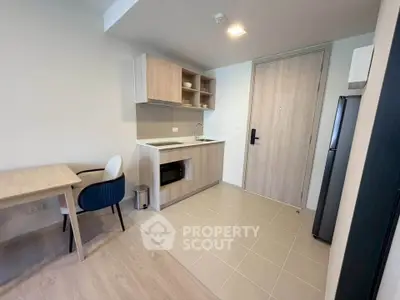 Modern kitchen with sleek cabinetry and dining area in a compact apartment