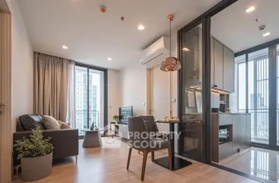 Modern open-plan living room with kitchen and balcony view in luxury apartment.