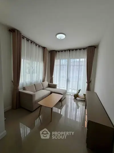 Modern living room with sleek furniture and large windows for natural light.