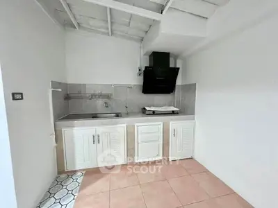 Charming minimalist kitchen with sleek cabinetry and modern range hood