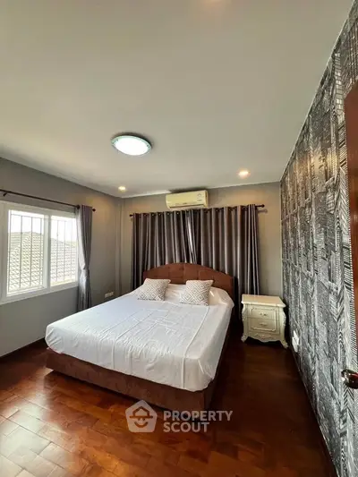 Cozy bedroom with stylish decor and natural light, featuring a comfortable bed and elegant curtains.