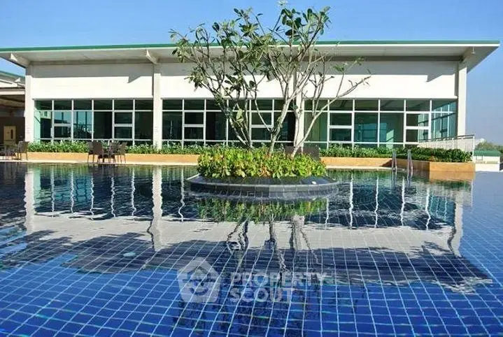 Luxurious rooftop pool with modern building backdrop and lush greenery.
