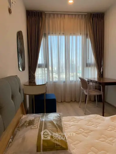 Cozy bedroom with large window and elegant curtains, featuring a comfortable bed and stylish furniture.