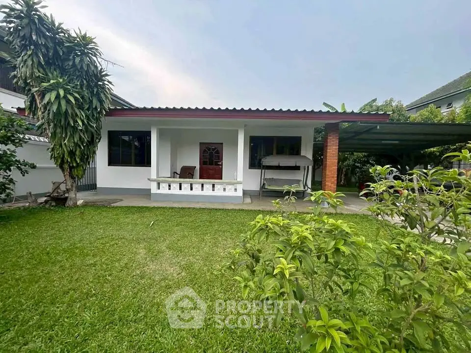 Charming single-story home with lush garden and covered patio, perfect for outdoor relaxation.