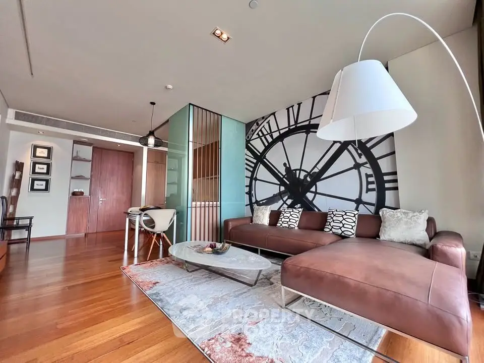 Luxurious living room with modern decor and large clock wall art, featuring elegant furniture and wooden flooring.